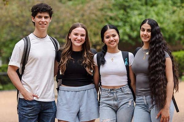 Four students pose for a photo on 博彩网址大全's campus